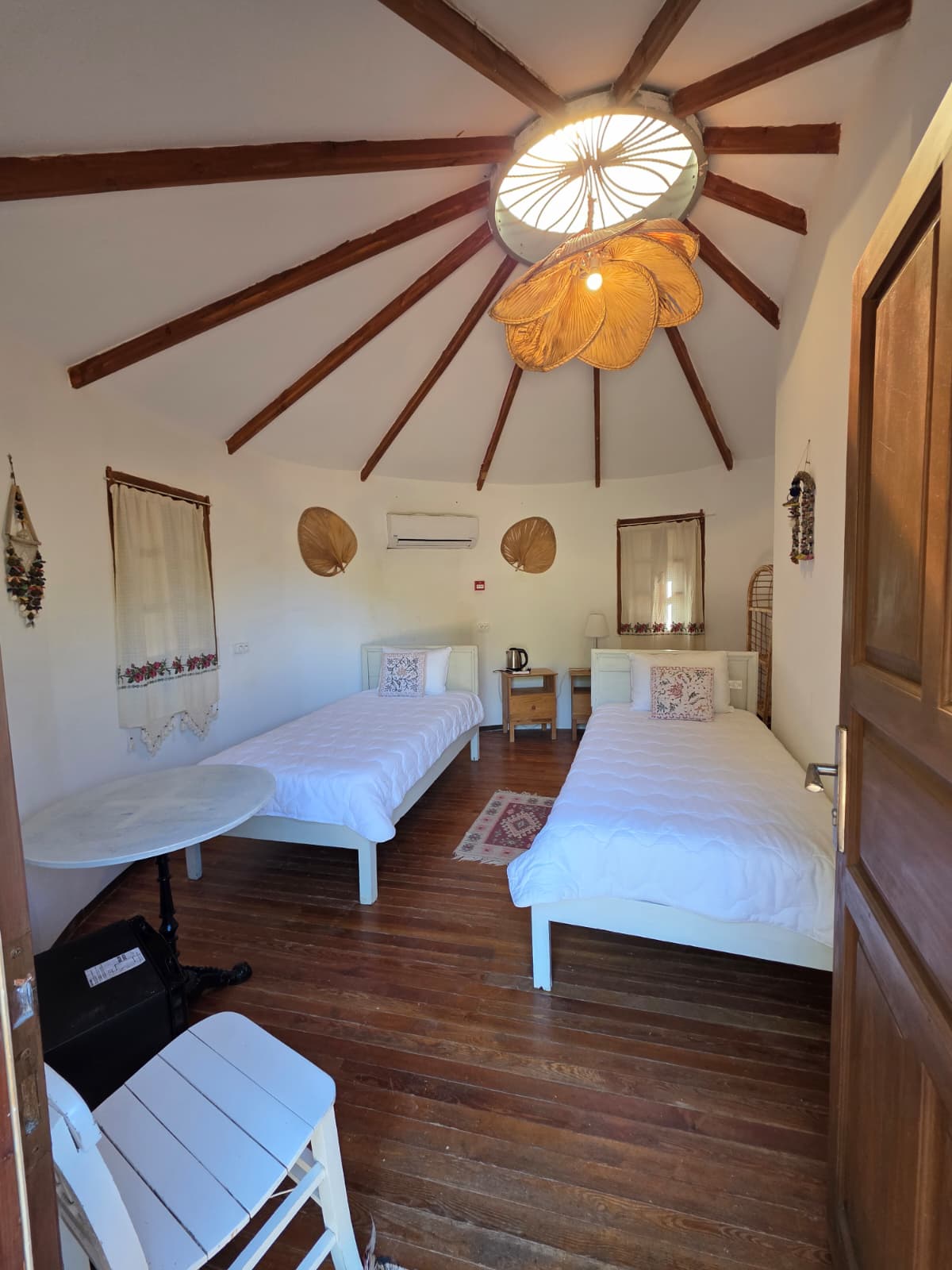 Standard twin room with two single beds under a round wood ceiling